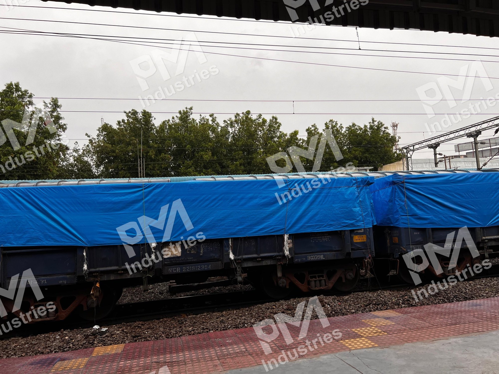 BOX-N Wagons Covered with Blue Tarpaulin at a Rail Platform